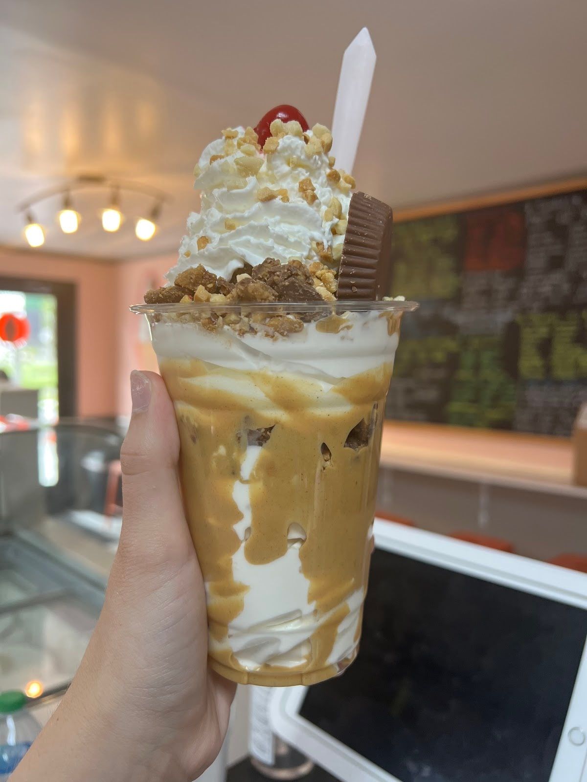 A caramel shake topped with whipped cream and a peanut butter cup